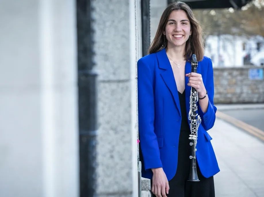 Margot Maurel holding a clarinet in a blue blazer